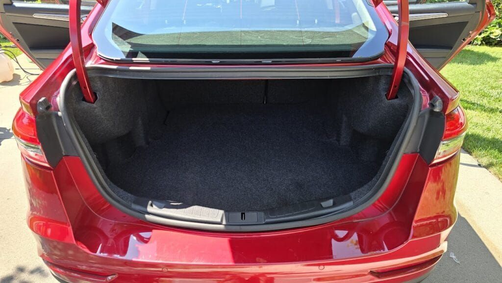 Red car trunk open, revealing a spacious interior.