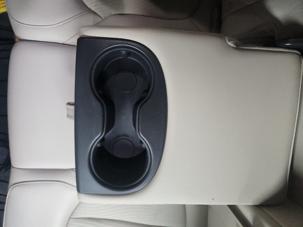 Beige car seat with a black cup holder.