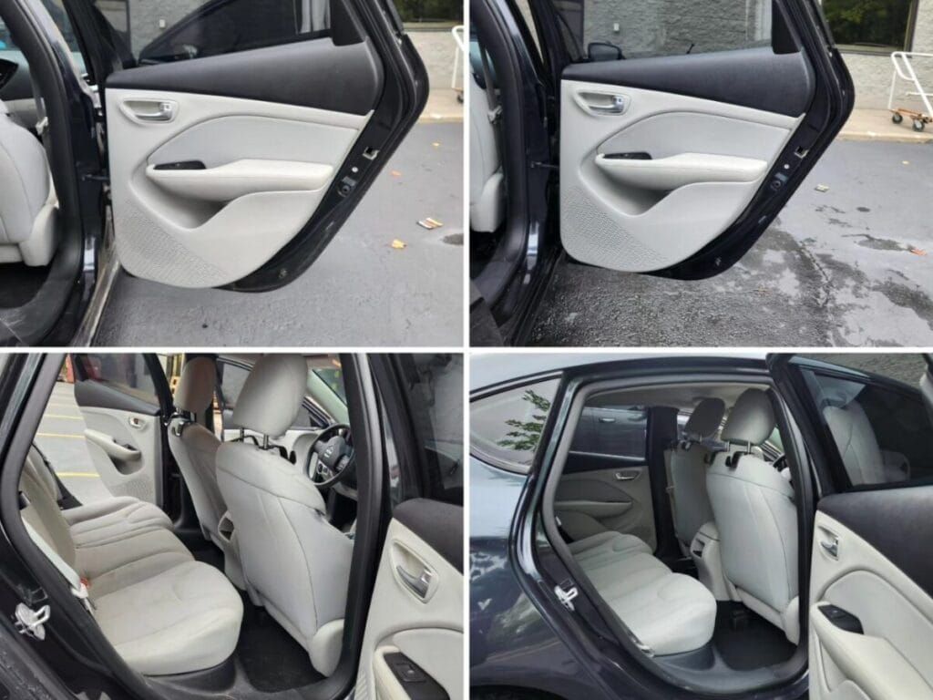 Car interior: gray and white seats, black door frame, view of front and back seats.