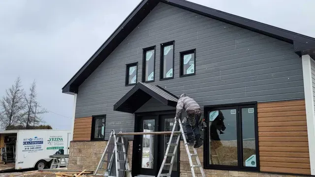Un homme est debout sur une échelle devant un bâtiment.