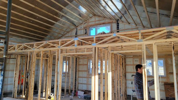 Un homme se tient à l’intérieur d’un immeuble en construction.