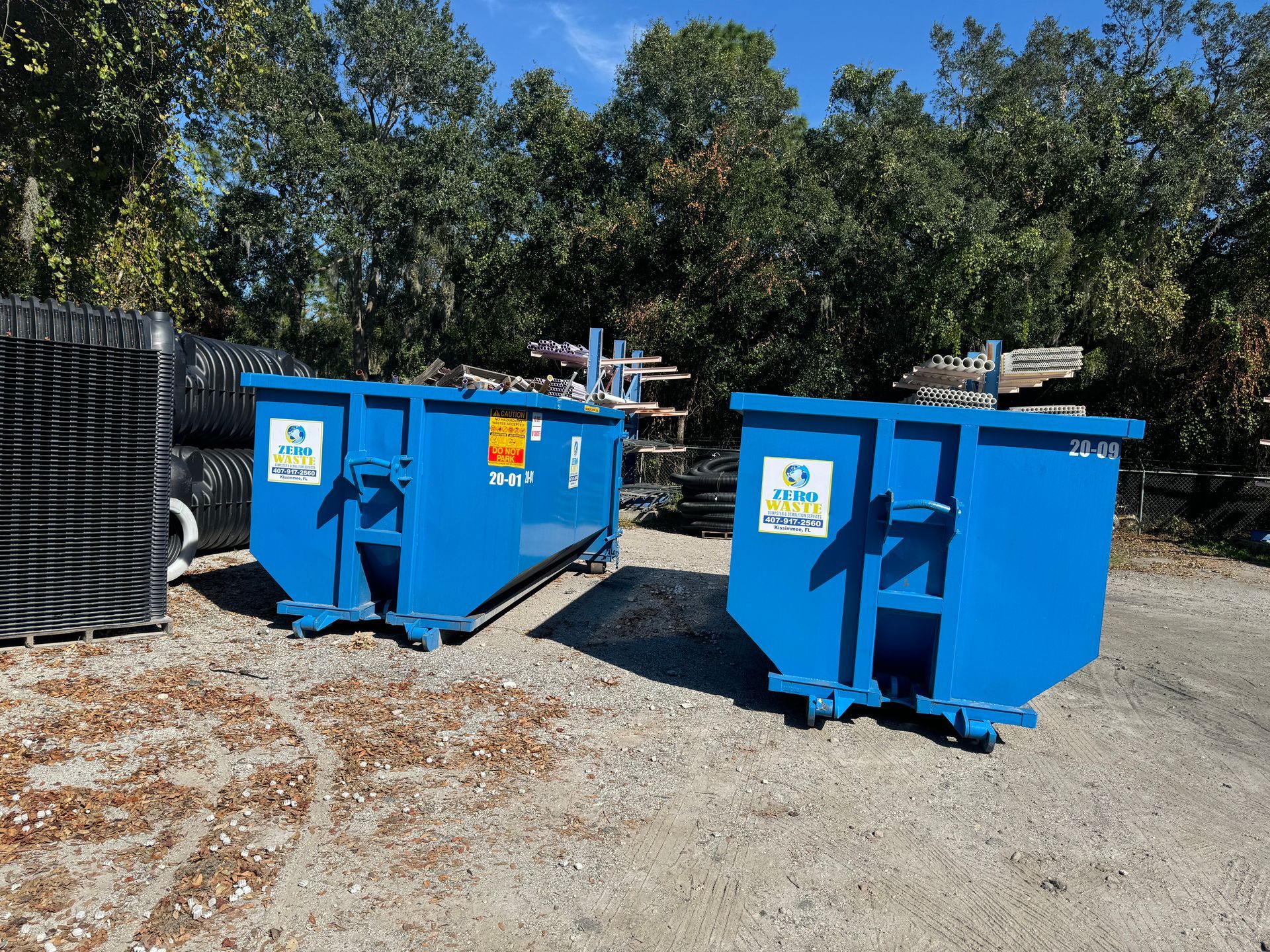 Blue waste container with three compartments, on a brick sidewalk.