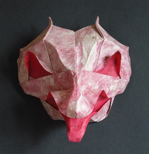 An origami goblin maskwith protruding tongue and little horns.