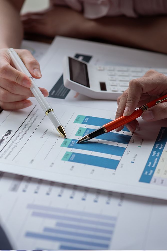 A person is pointing at a graph on a piece of paper with a pen.