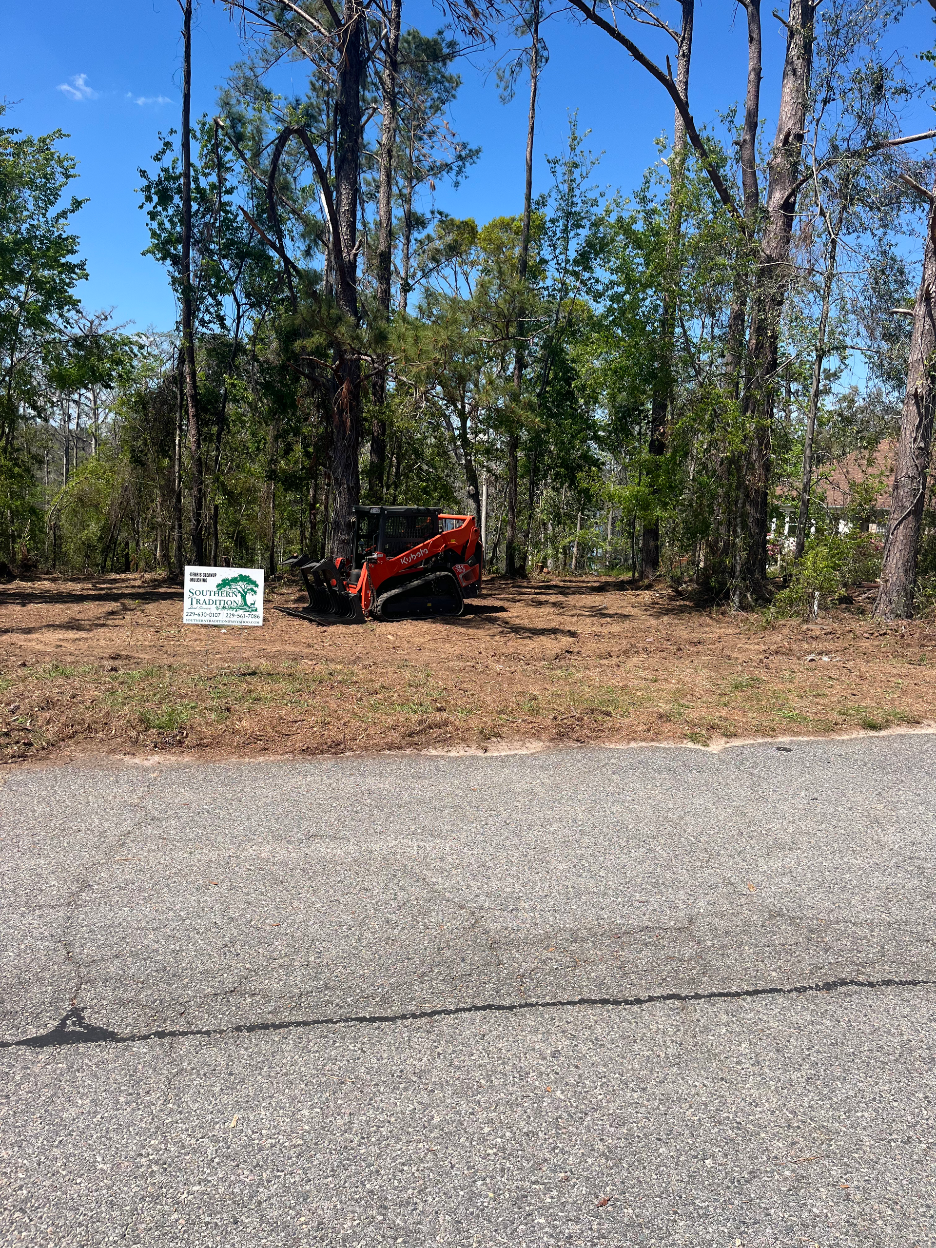A red atv is parked on the side of the road next to a sign.