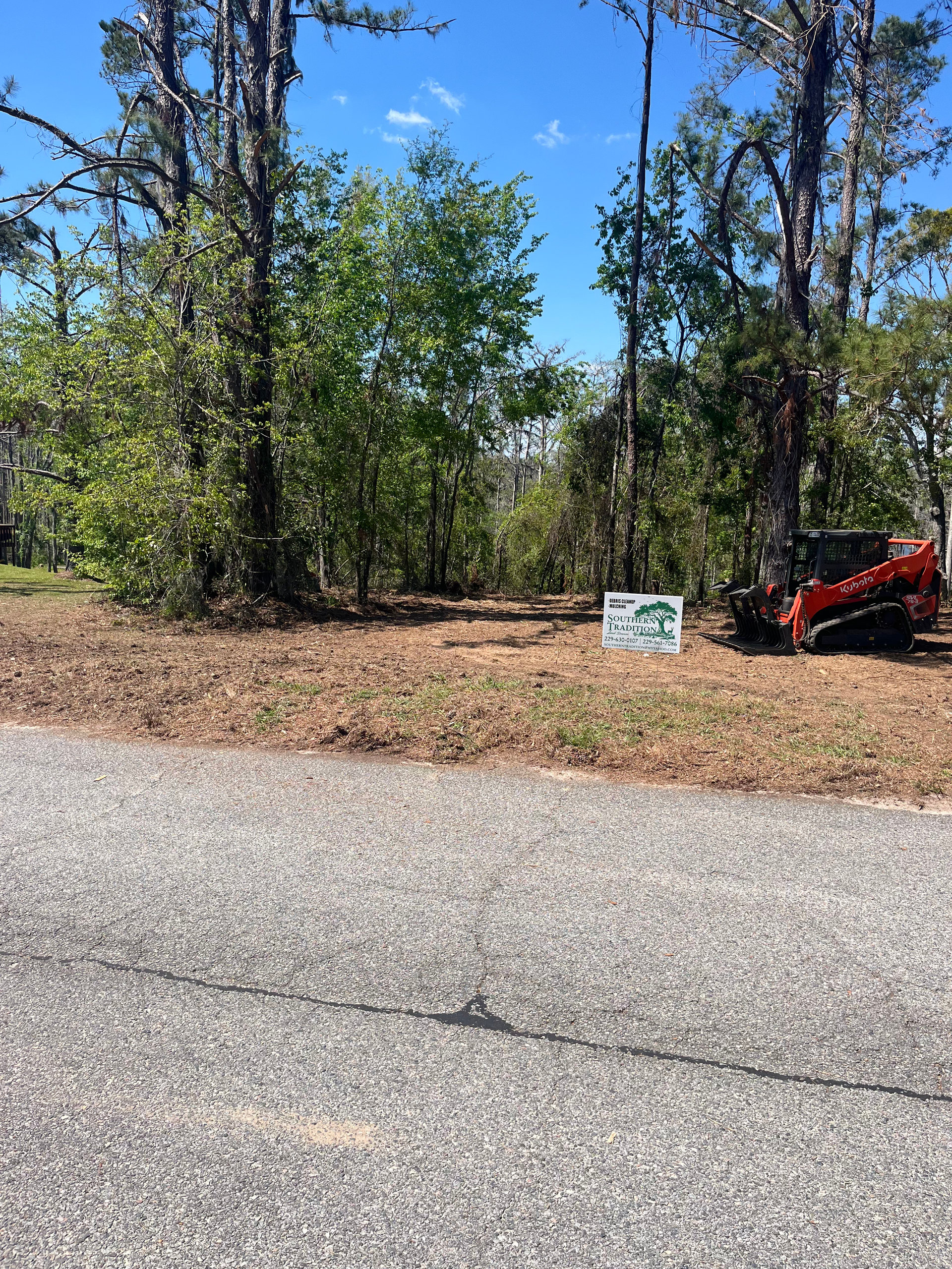 A red atv is parked on the side of the road next to a sign.