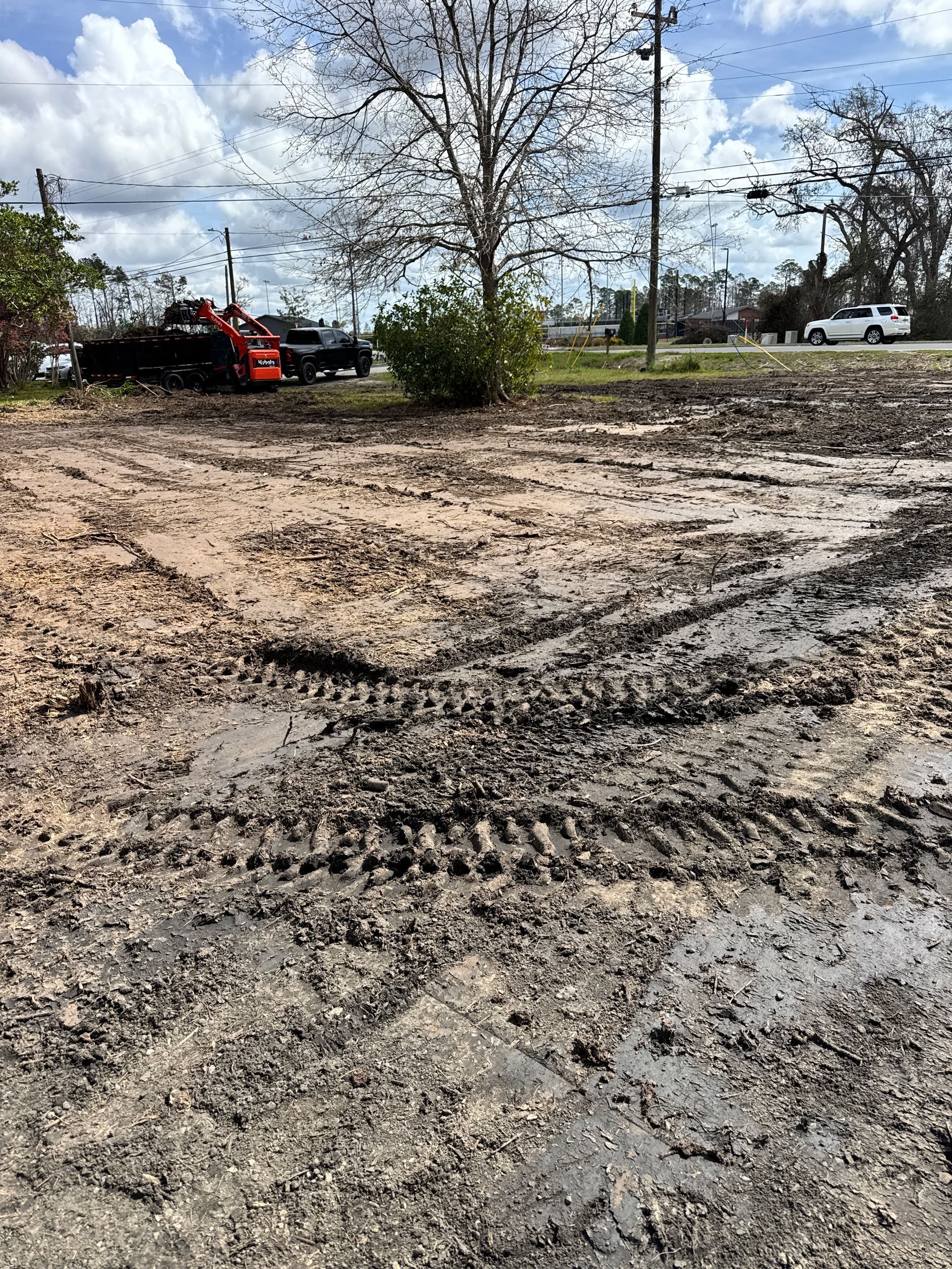 A muddy field with a truck parked in the background.