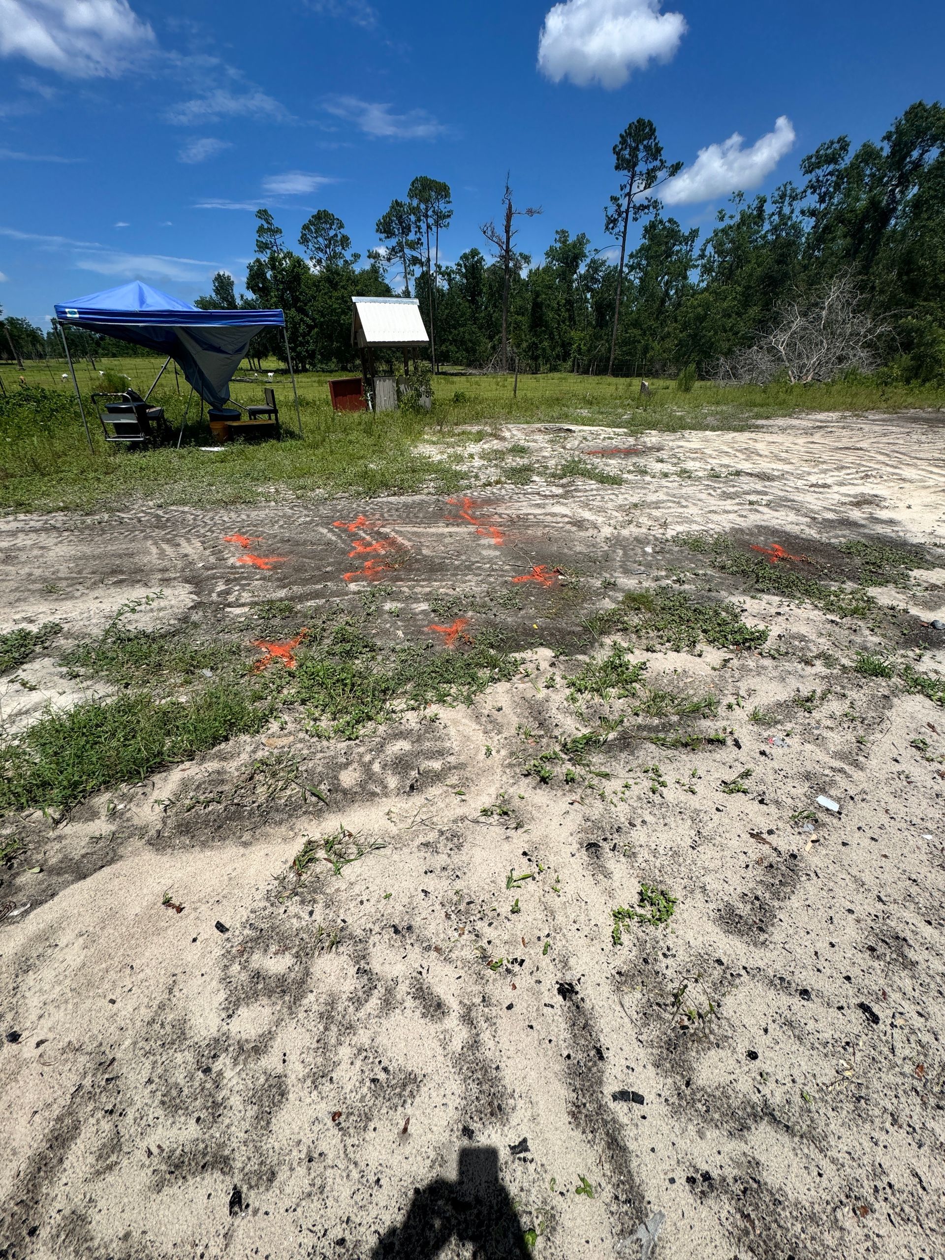 A helicopter is parked in the middle of a dirt field