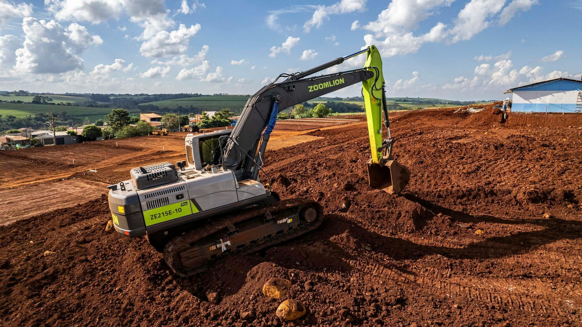 A large excavator is sitting on top of a dirt field.