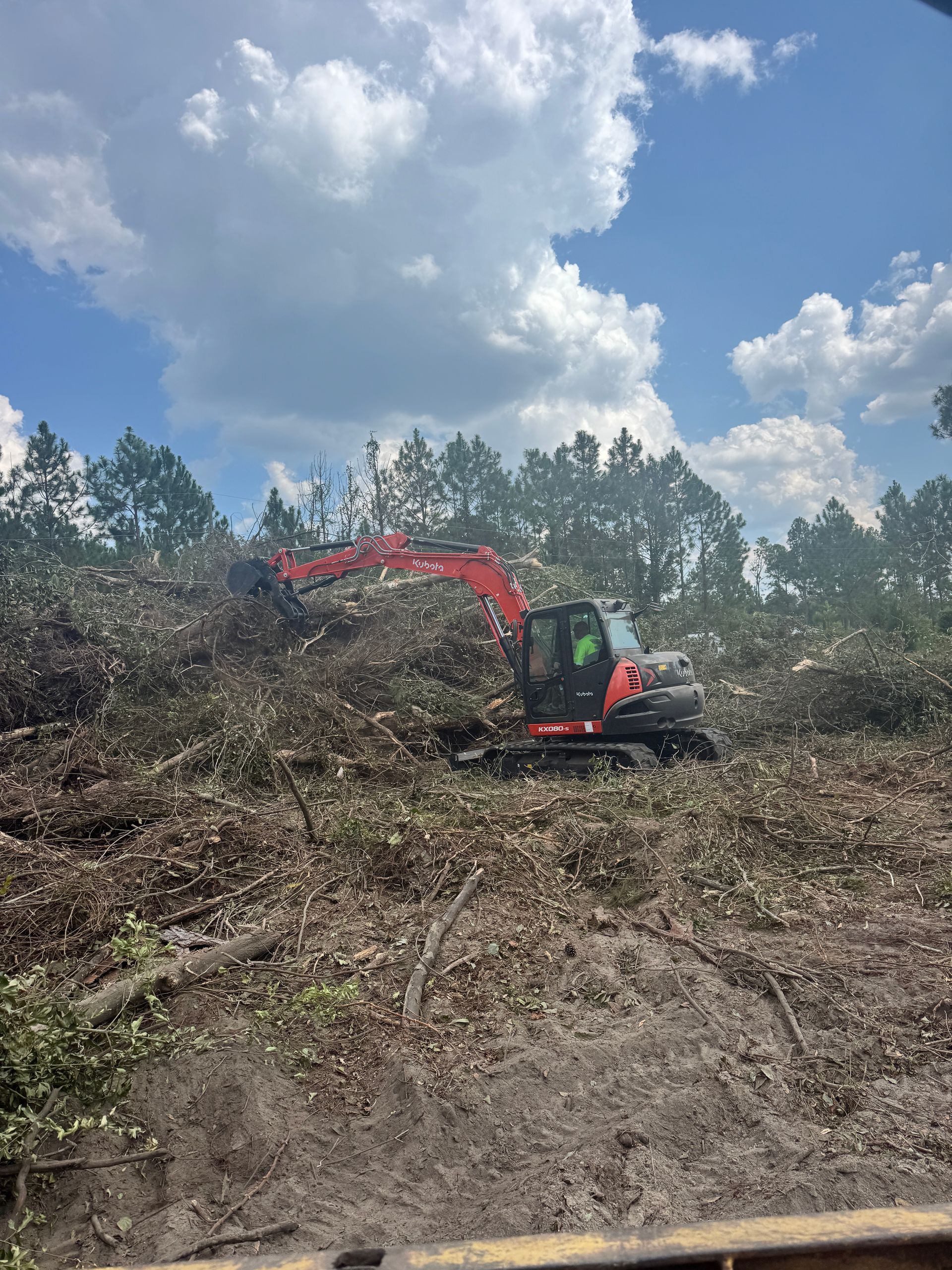 A yellow excavator is digging in a pile of dirt.