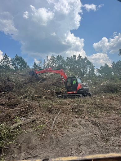 A yellow excavator is digging in a pile of dirt.