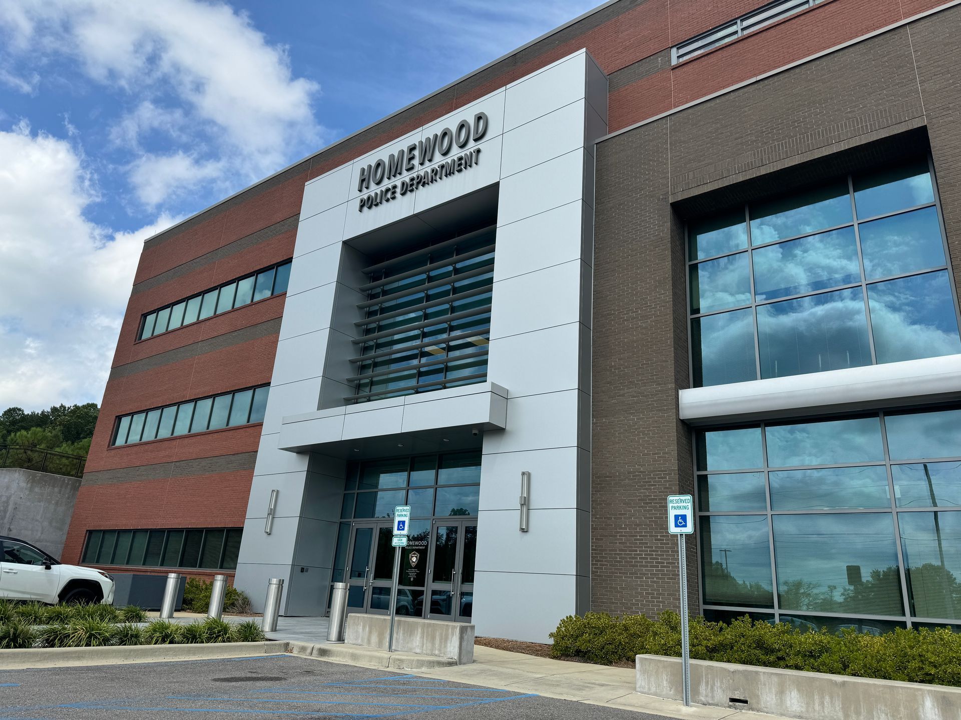 A large brick building with a parking lot in front of it.