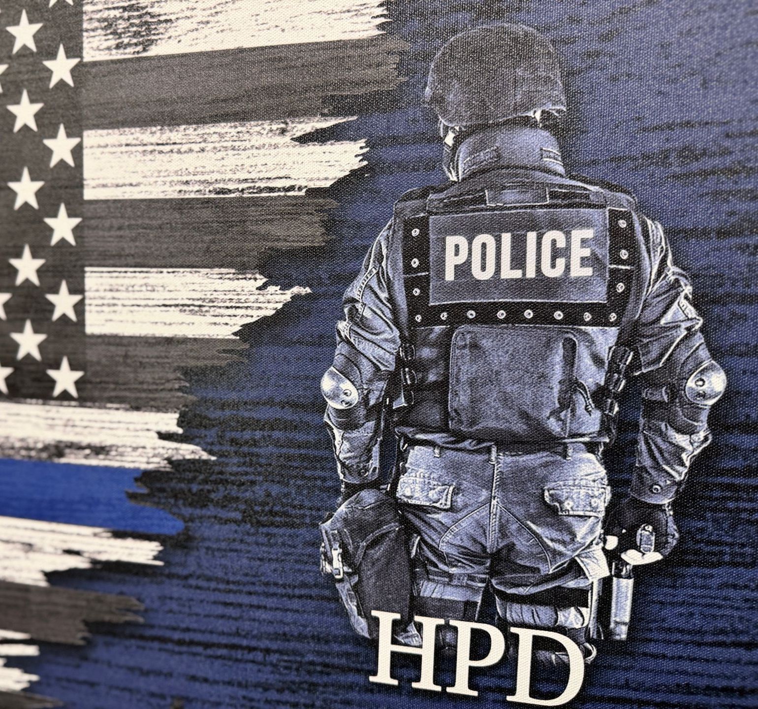 A police officer is standing in front of an american flag.