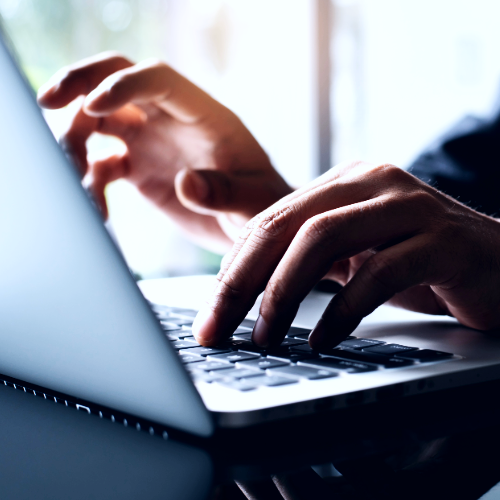 A close up of a person 's hands typing on a laptop