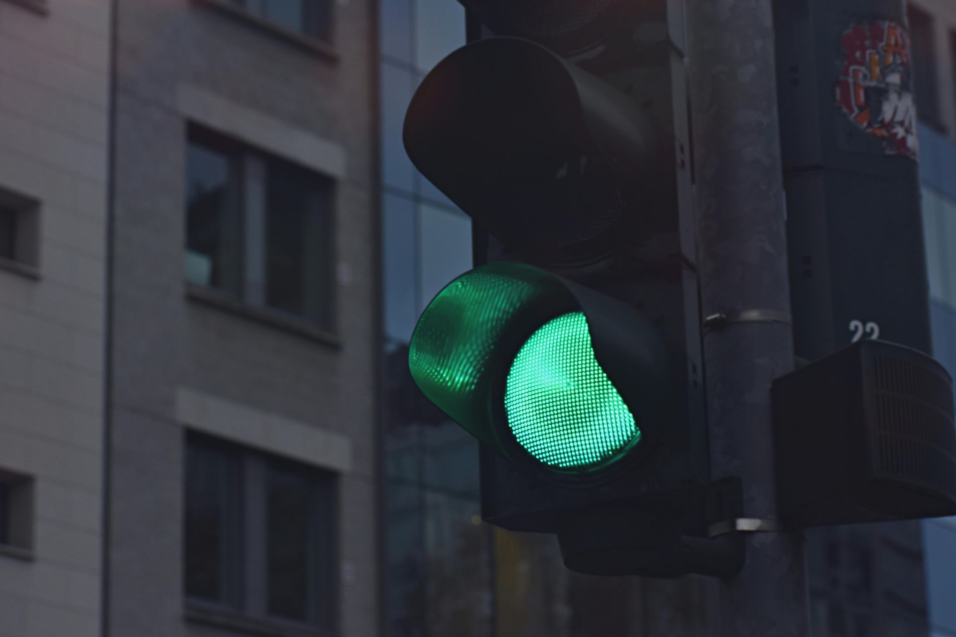 A green traffic light is lit up in front of a building.