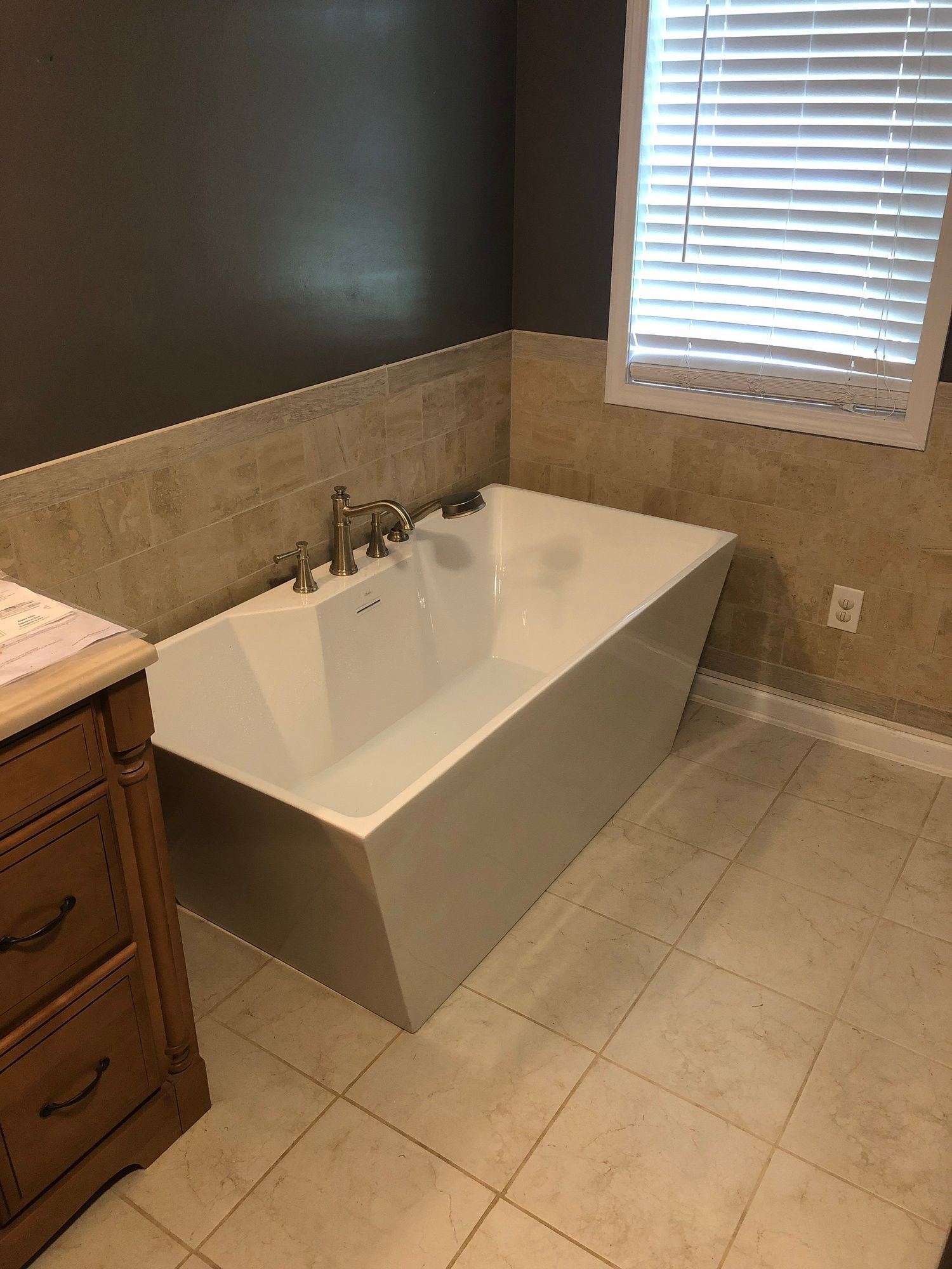 A bathtub is sitting in a bathroom next to a window.
