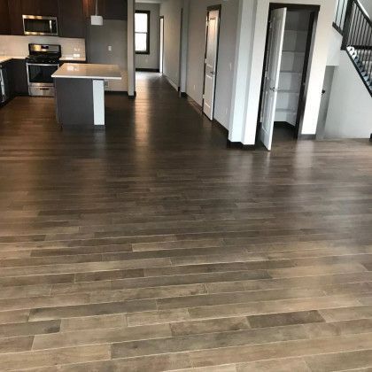 A kitchen with a wooden floor and a staircase