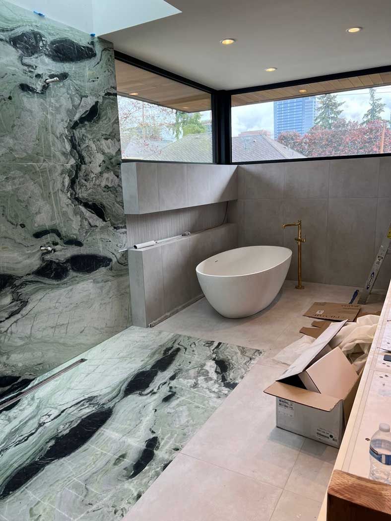 A bathroom with a bathtub and a large window.