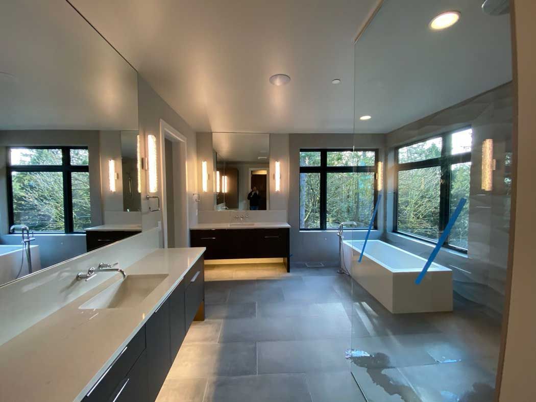 A bathroom with two sinks , a bathtub and a large mirror.