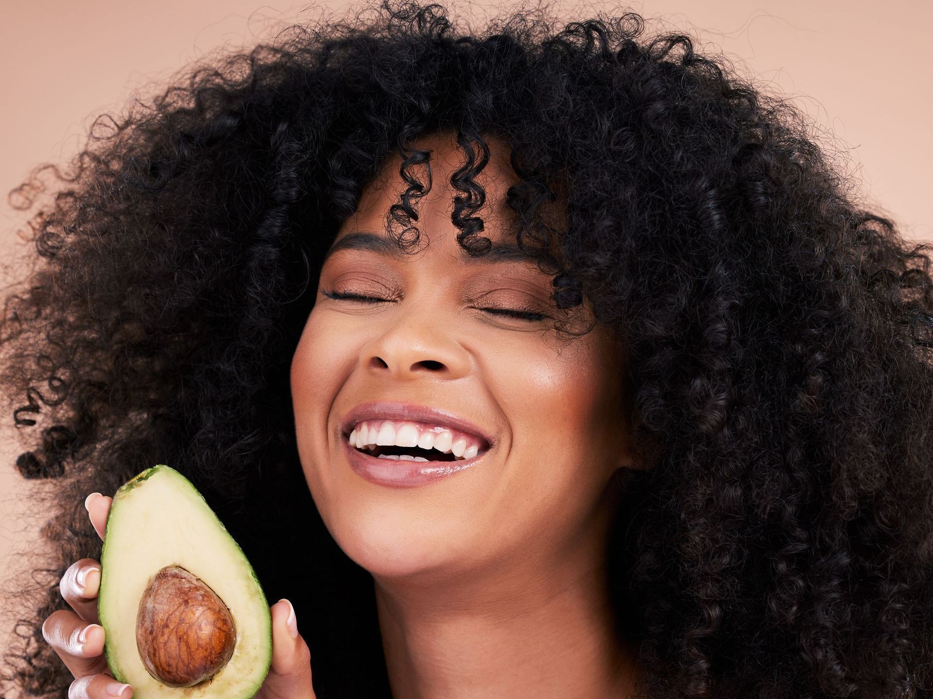 Happy woman holding avocado