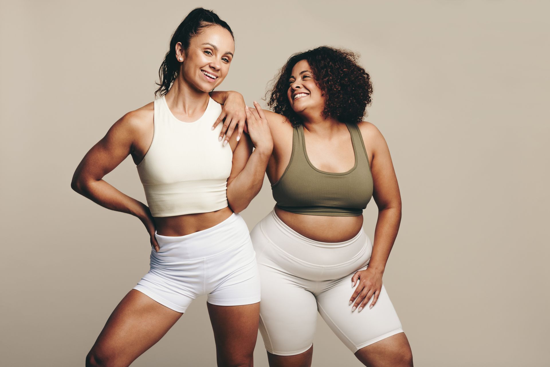 Two women are standing next to each other and smiling for the camera.