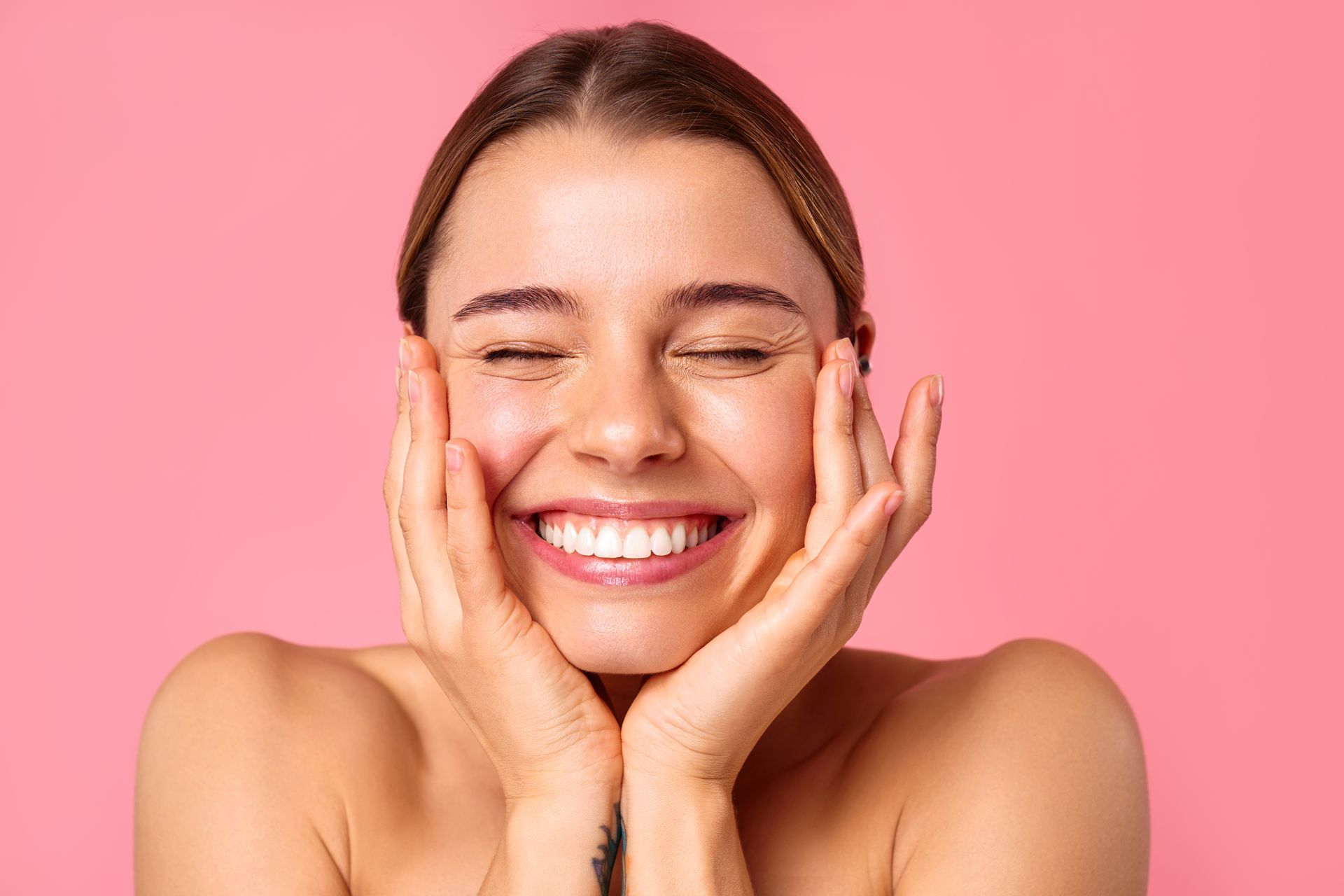 A woman is touching her face.