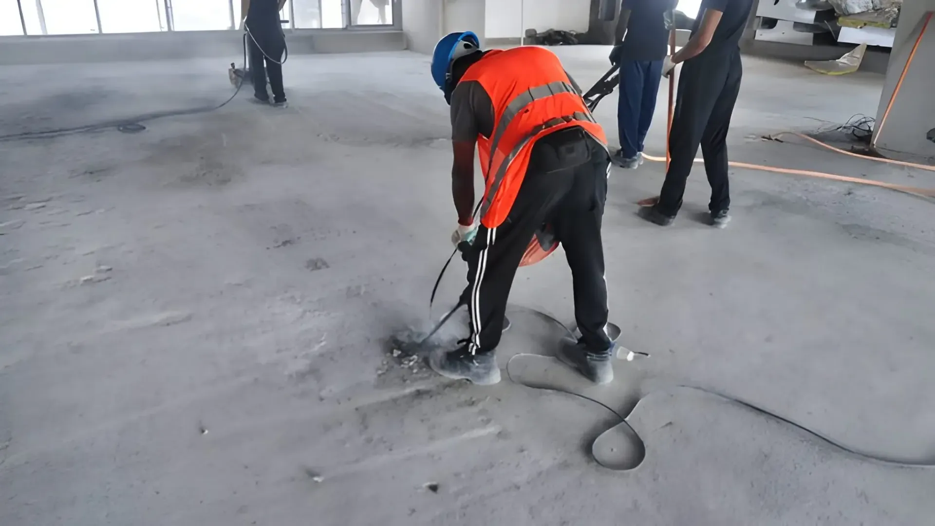 Construction crew using specialized equipment to repair damaged concrete foundation slab.