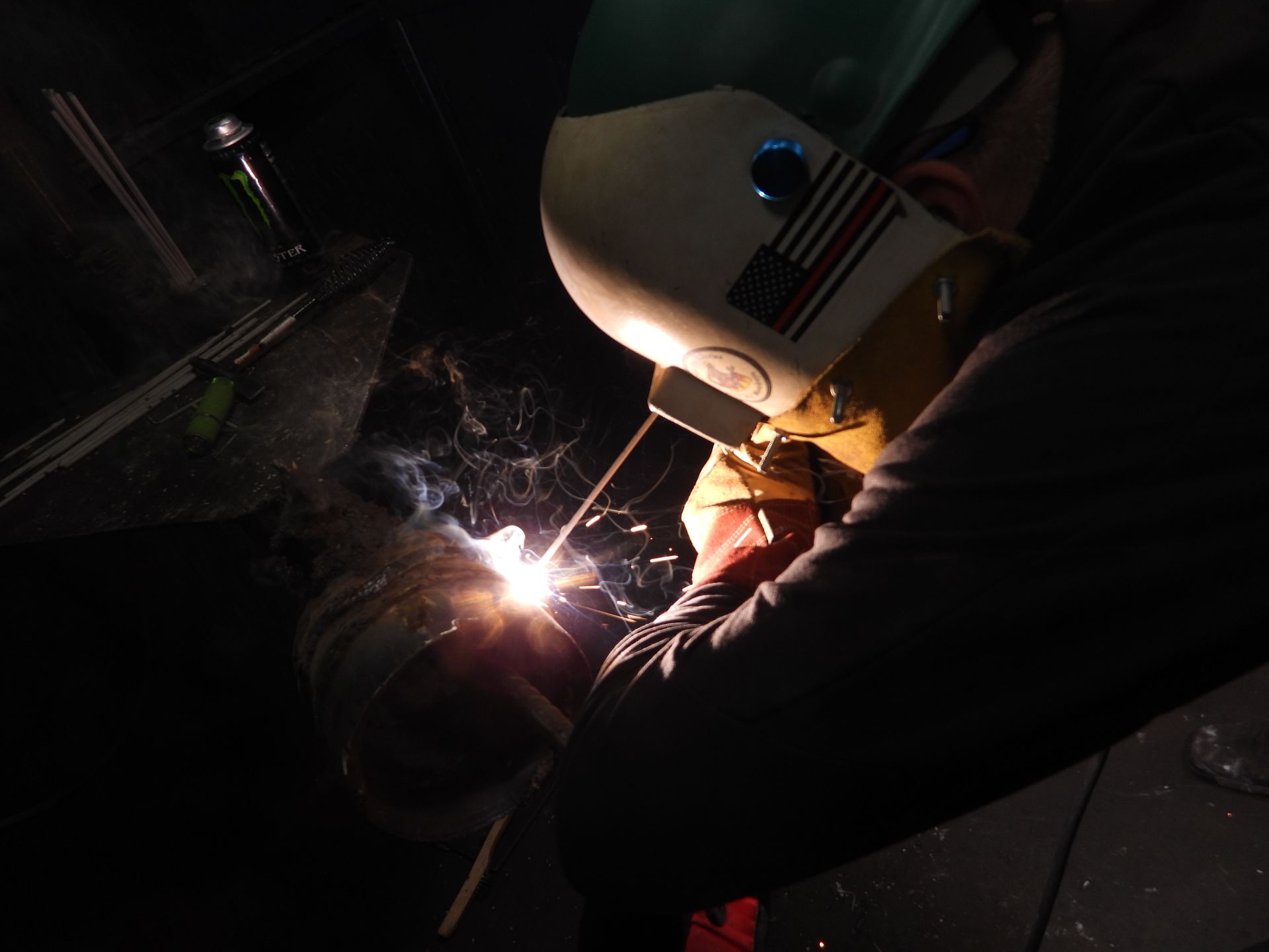 A man wearing a welding helmet with an american flag on it