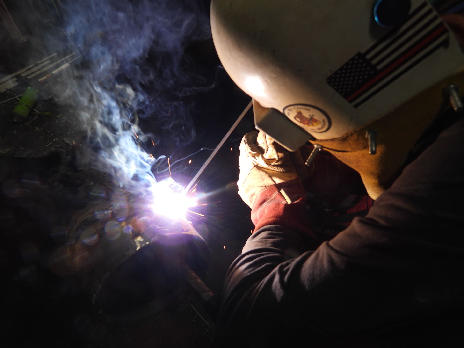 A man wearing a welding helmet with an american flag on it