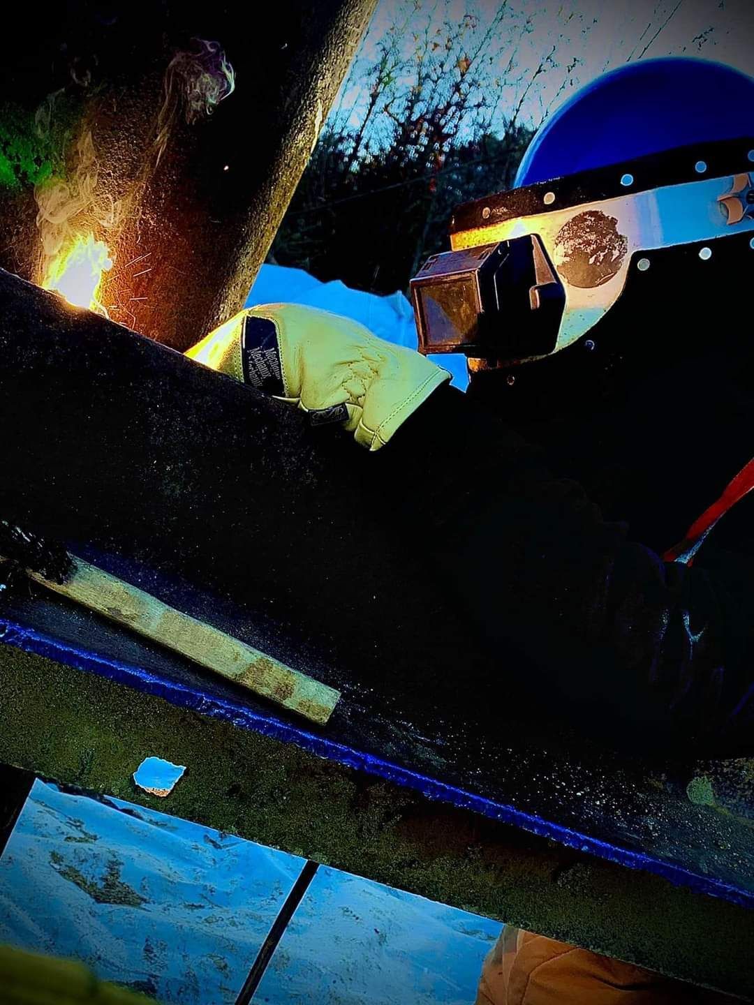 A person wearing a blue helmet is sitting on a skateboard