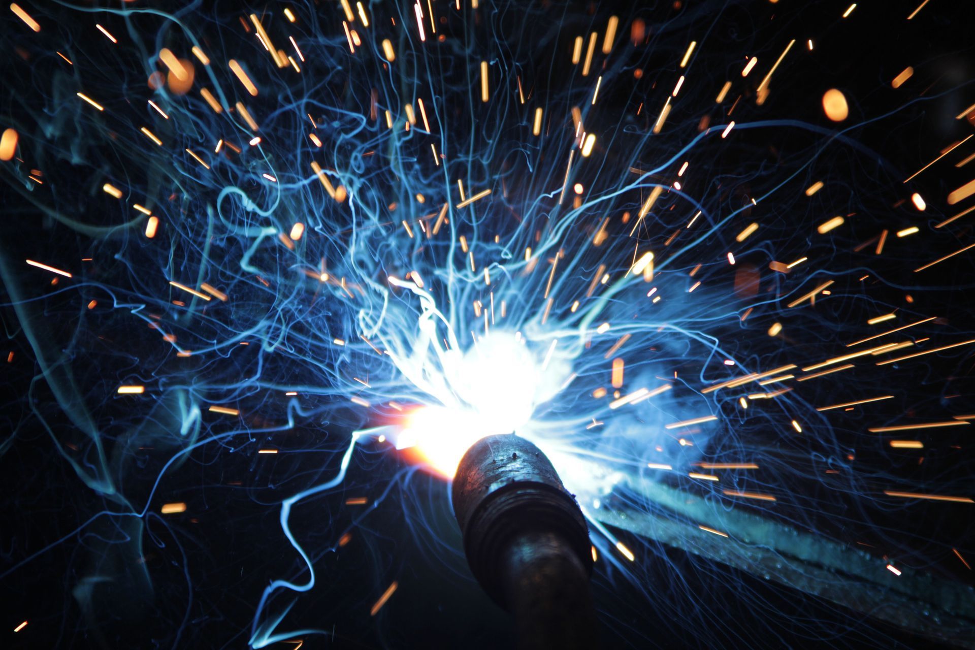 A close up of a welding machine with sparks coming out of it.