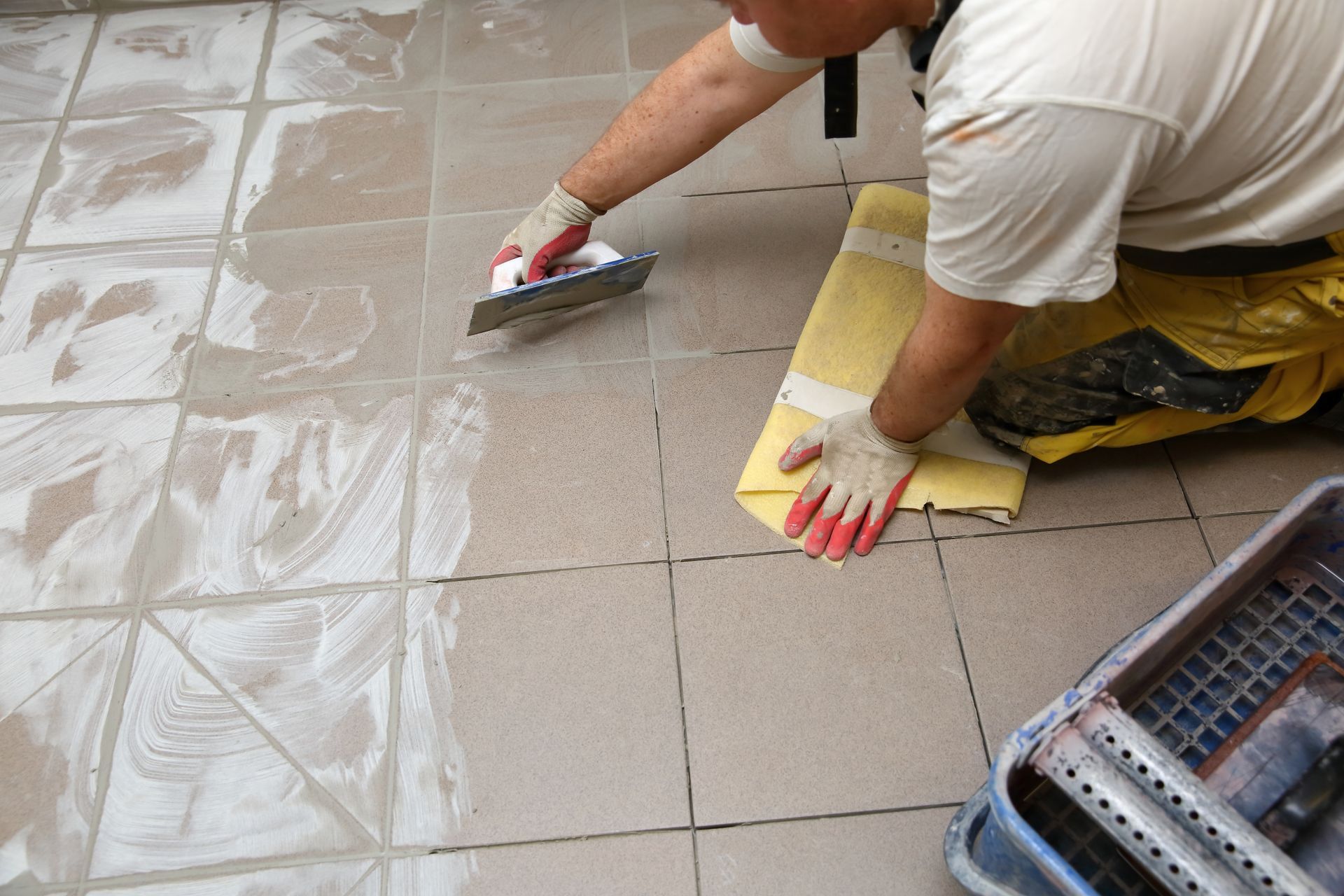 An experienced handyman applying grout to repair and revitalize tile surfaces.