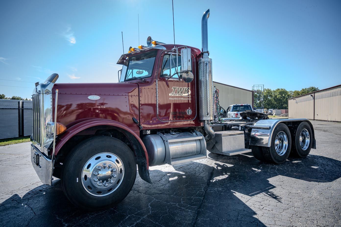 A red semi truck is parked in a parking lot after fleet detailing.