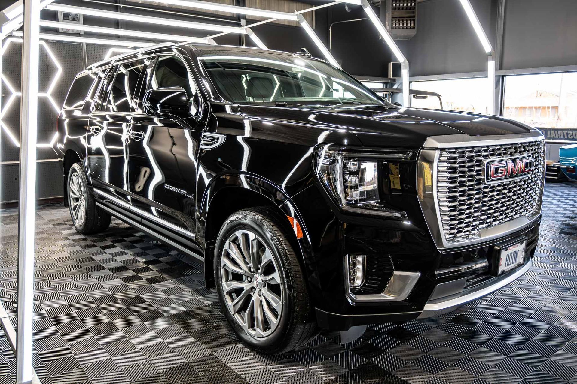 A black gmc yukon is parked in a showroom.