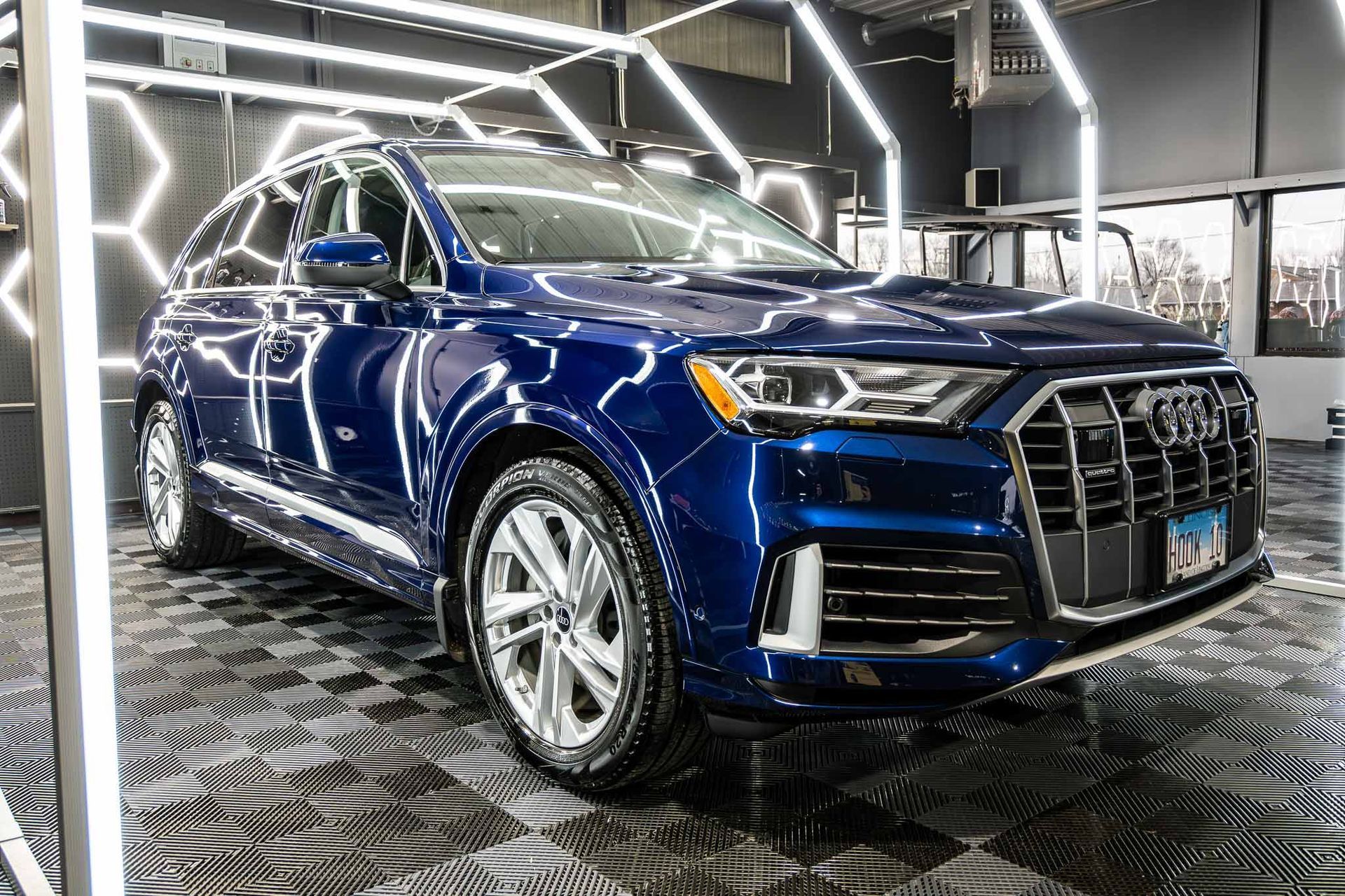 A blue audi q7 is parked in a garage.