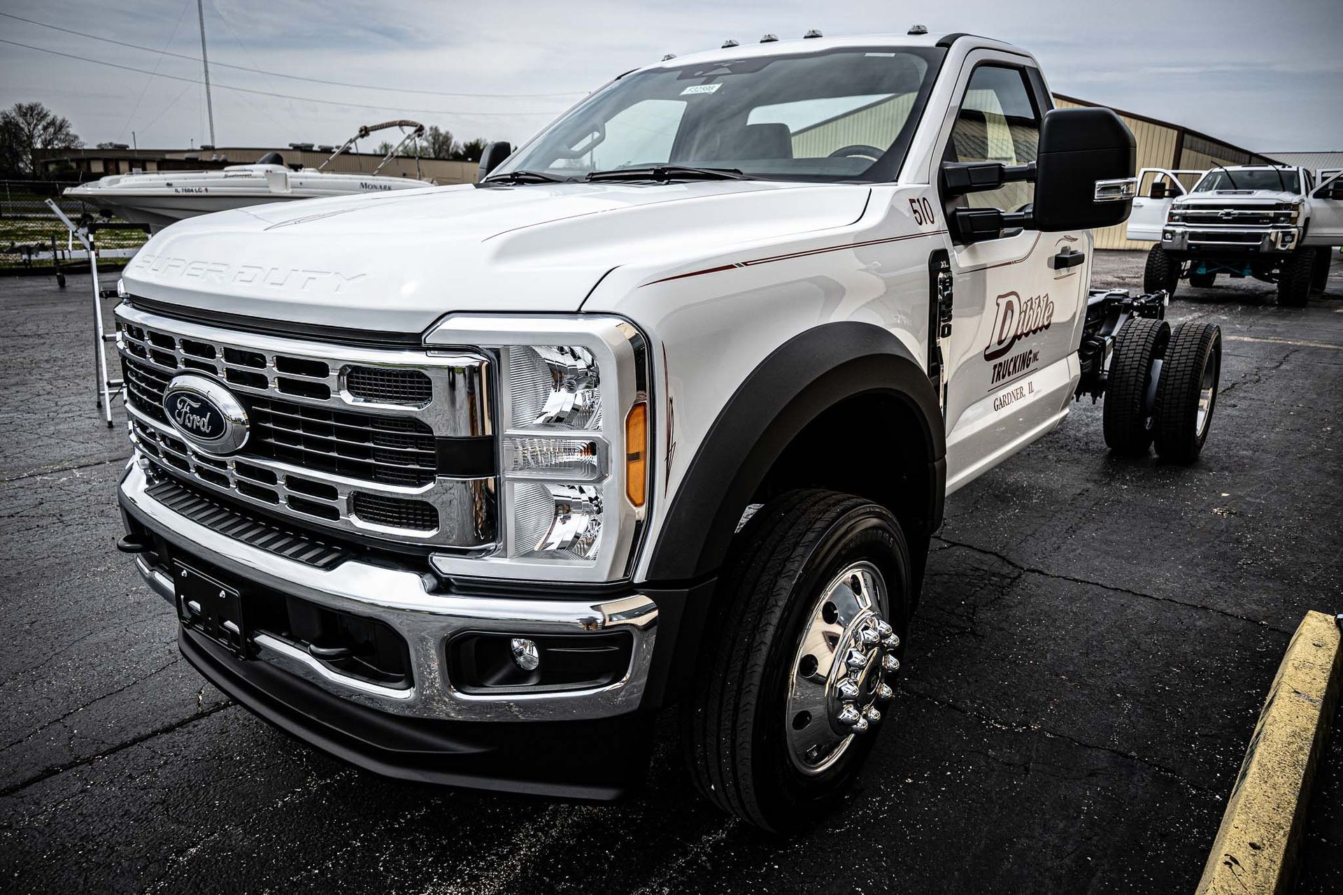 A white ford truck is parked in a parking lot.