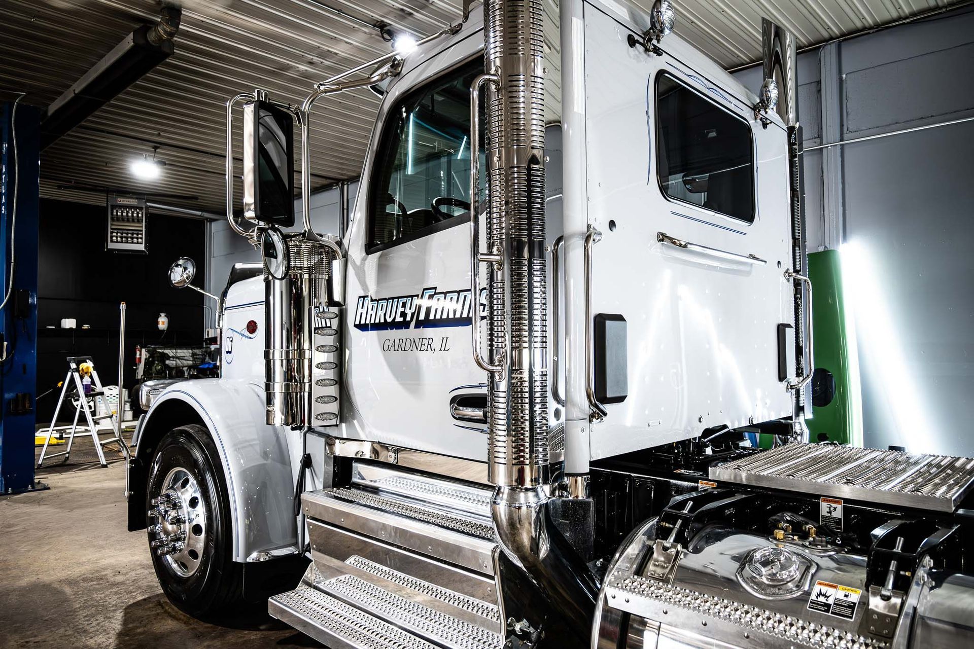 A white semi truck is parked in a garage after fleet detailing.