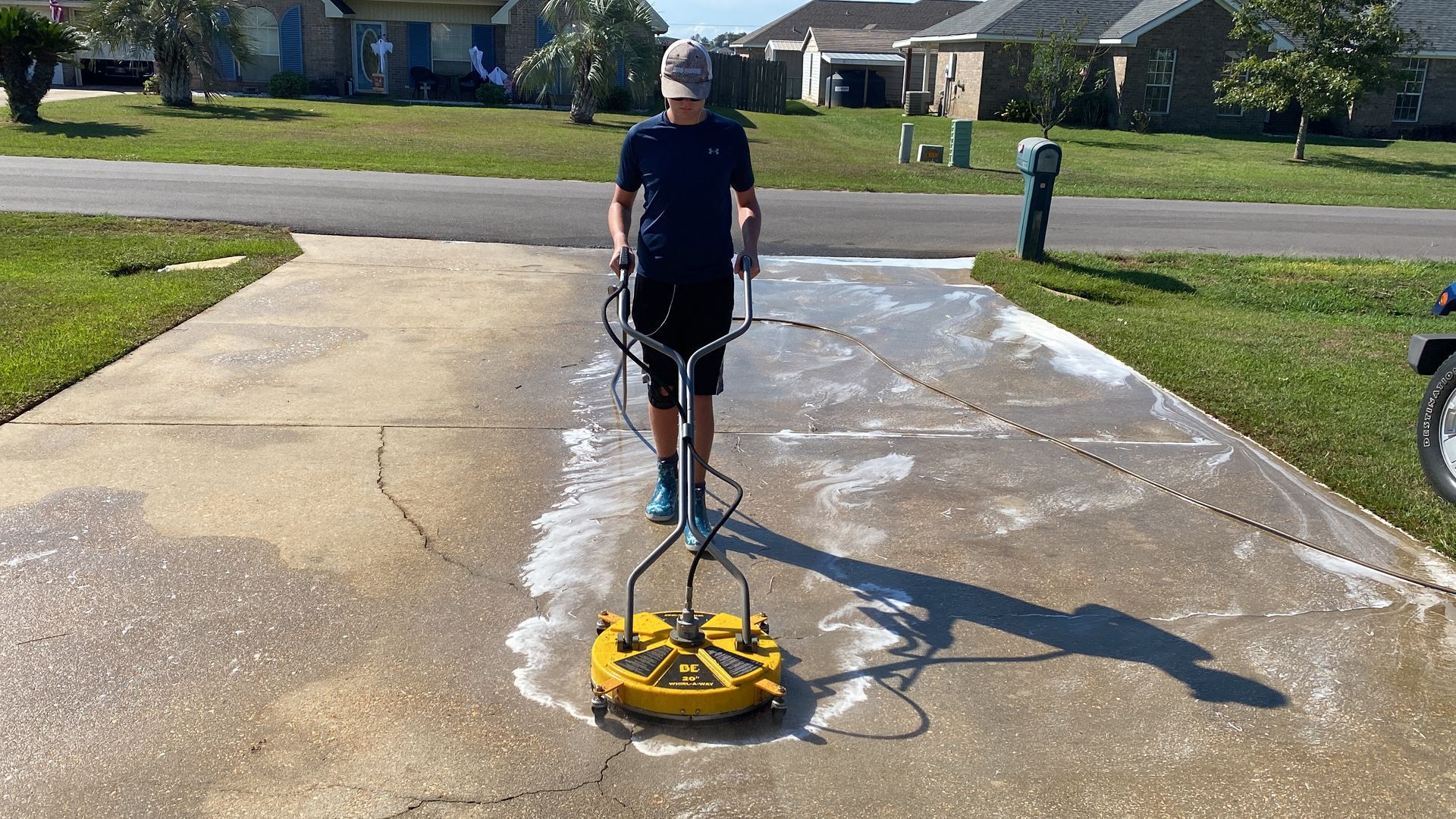 a man is pressure washing a driveway with a machine .