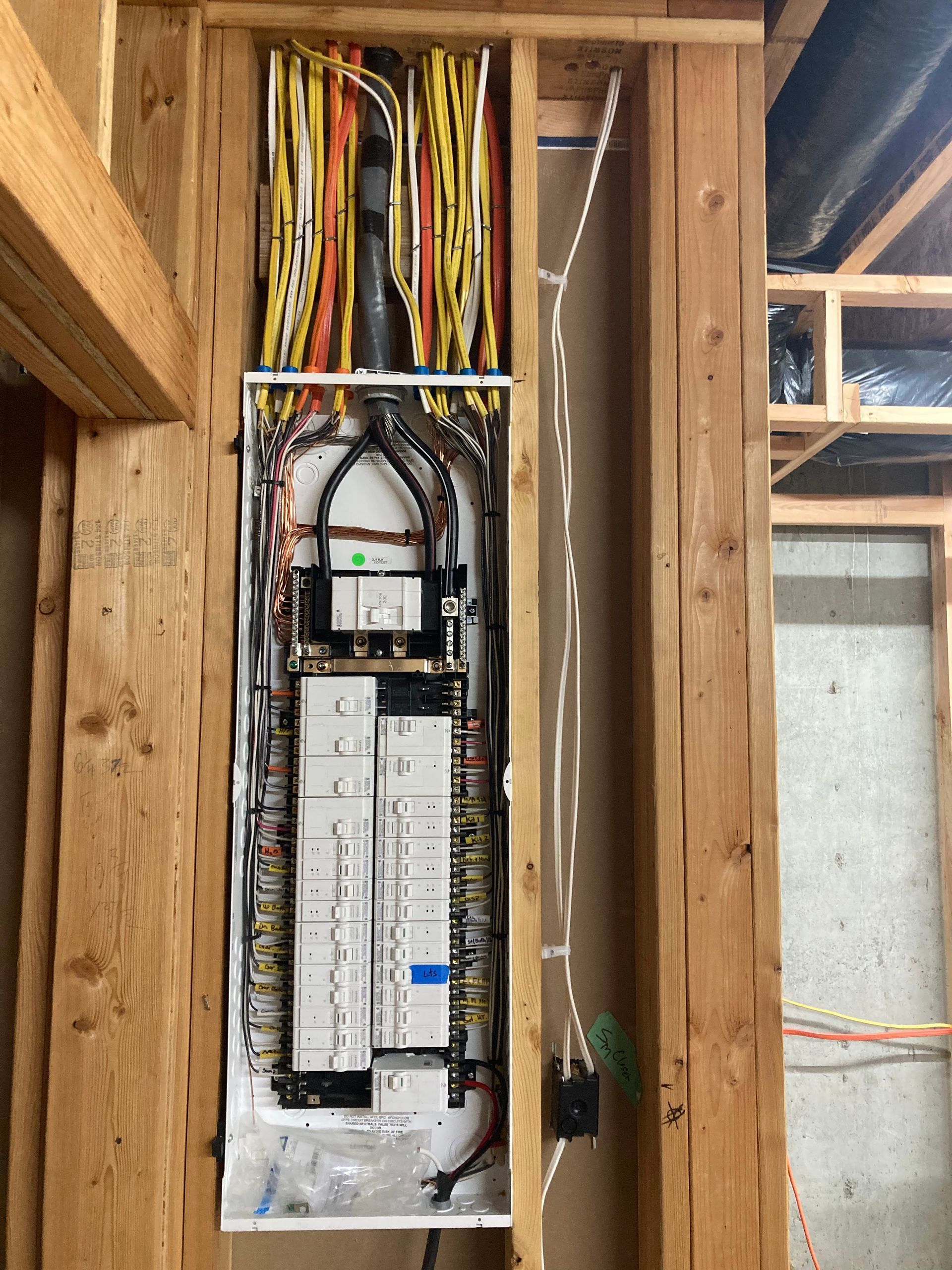 A large electrical box is hanging from a wooden wall.