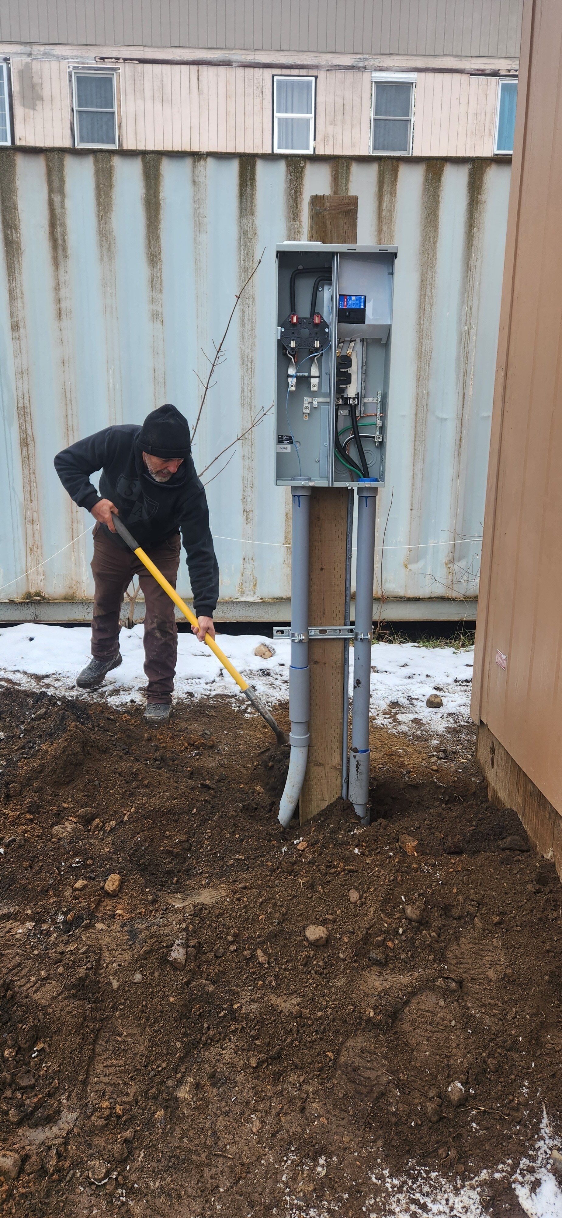 A man is digging in the dirt with a shovel.