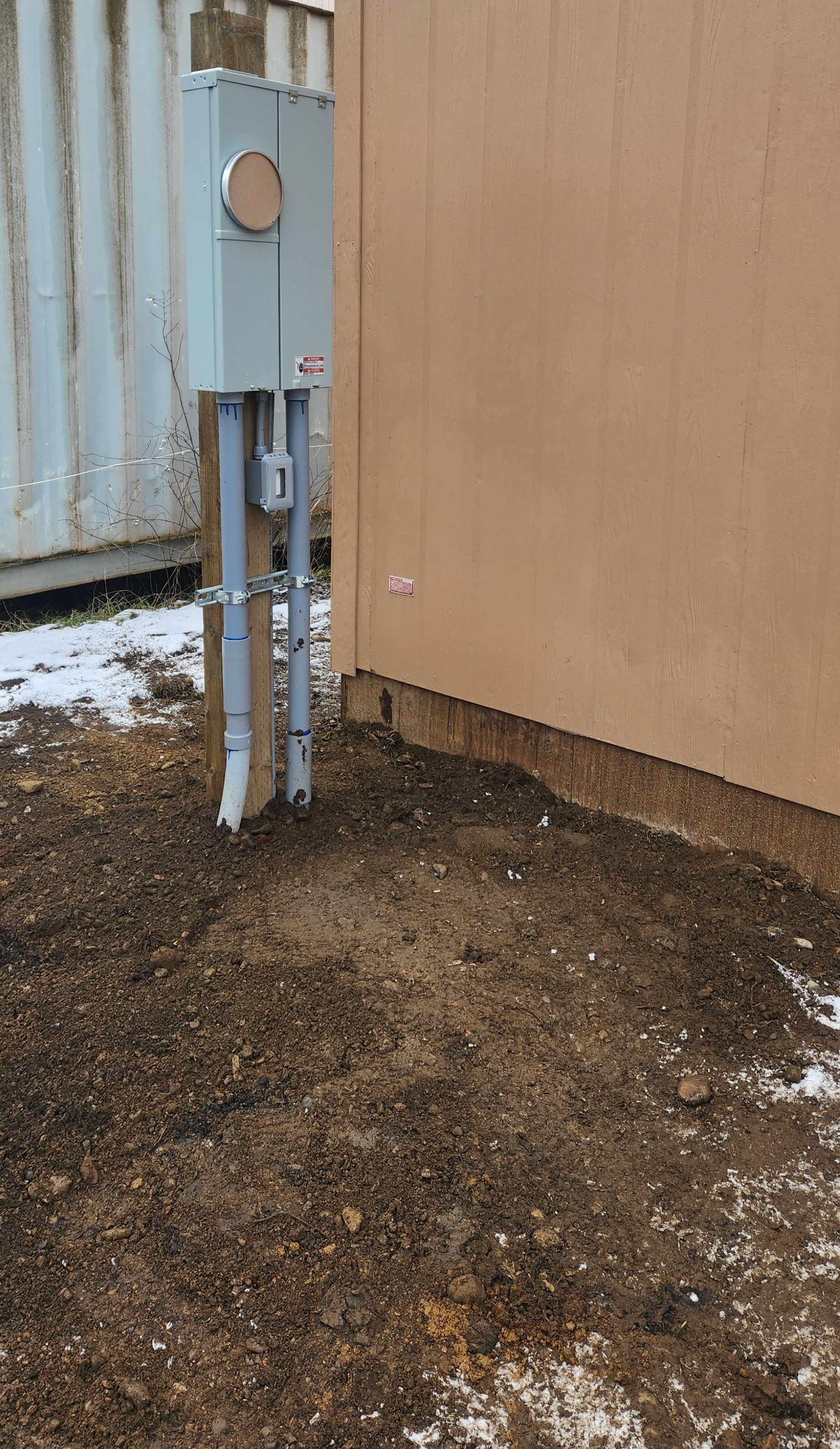 There is a electrical box on the side of a building.