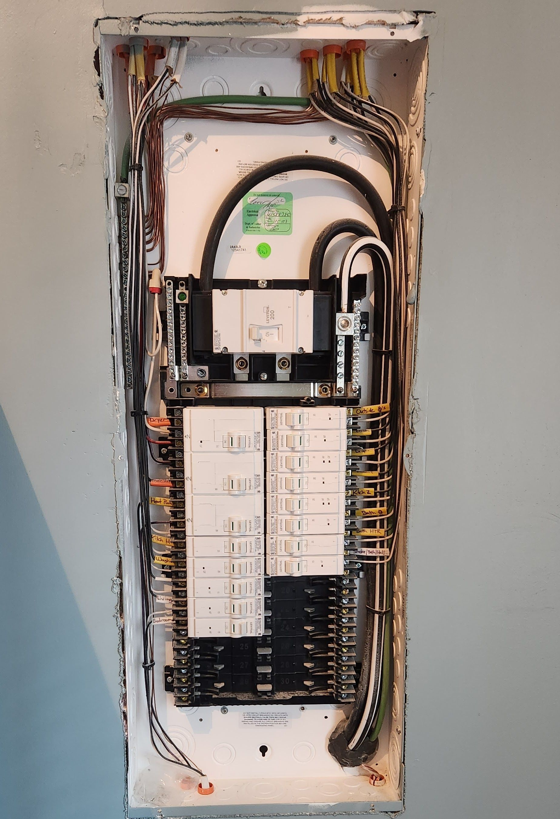 Electrical panel with wires and circuit breakers.