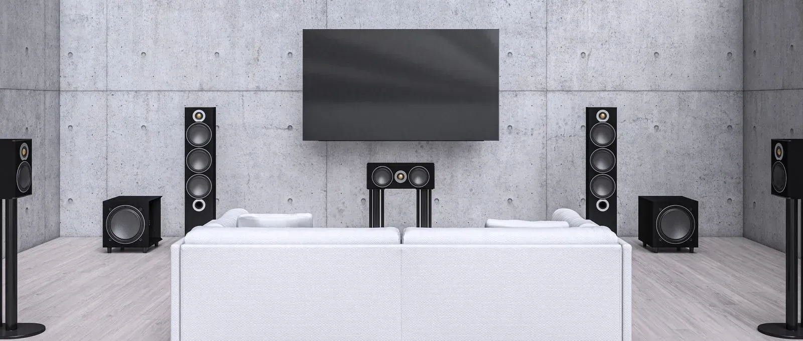 A living room with a couch , speakers , and a flat screen tv.