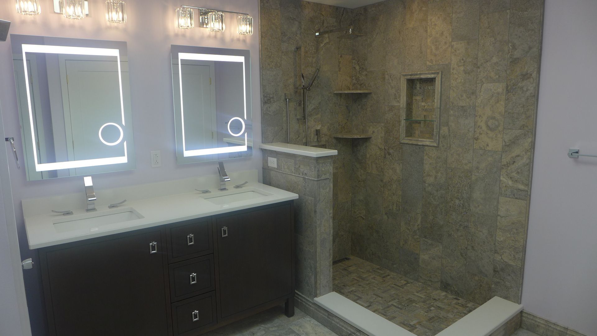 A bathroom with two sinks and a walk in shower.