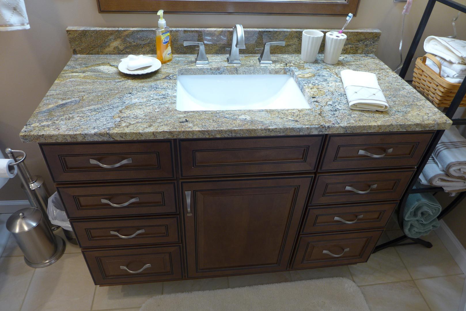 A bathroom vanity with a sink , drawers , and a mirror.