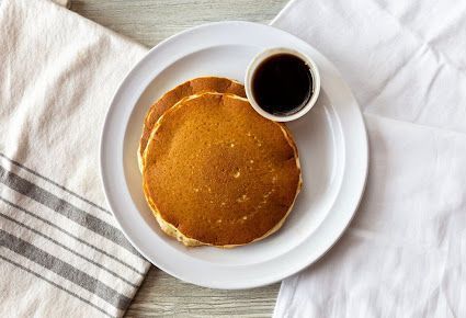 Stack of Pancakes with Blueberries and Syrup on a White Plate - Round Lake, IL - Eggspress Cafe
