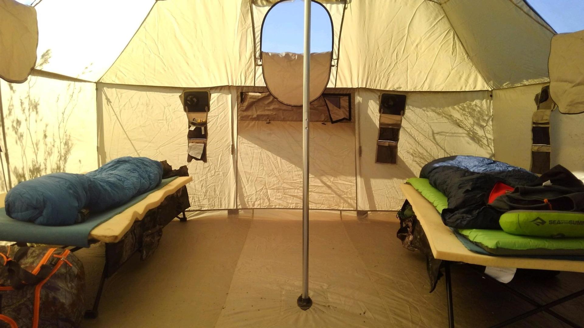 A tent with two beds and sleeping bags in it