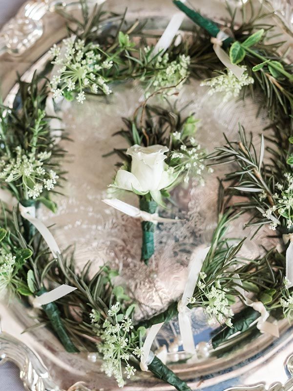 A silver plate topped with a wreath of flowers and greenery.