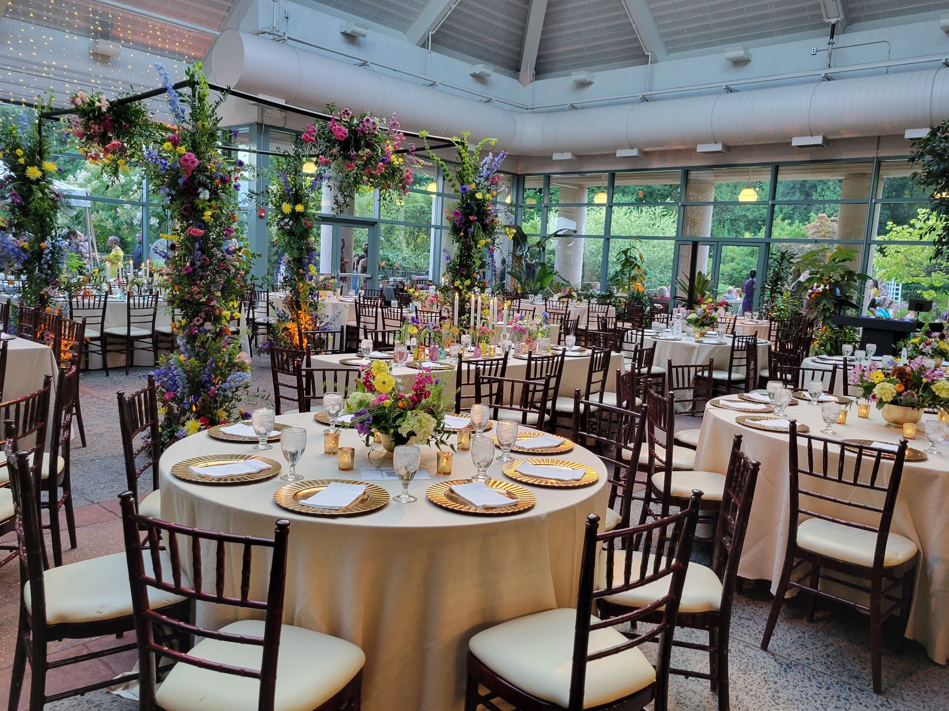 A large room with tables and chairs set up for a wedding reception.