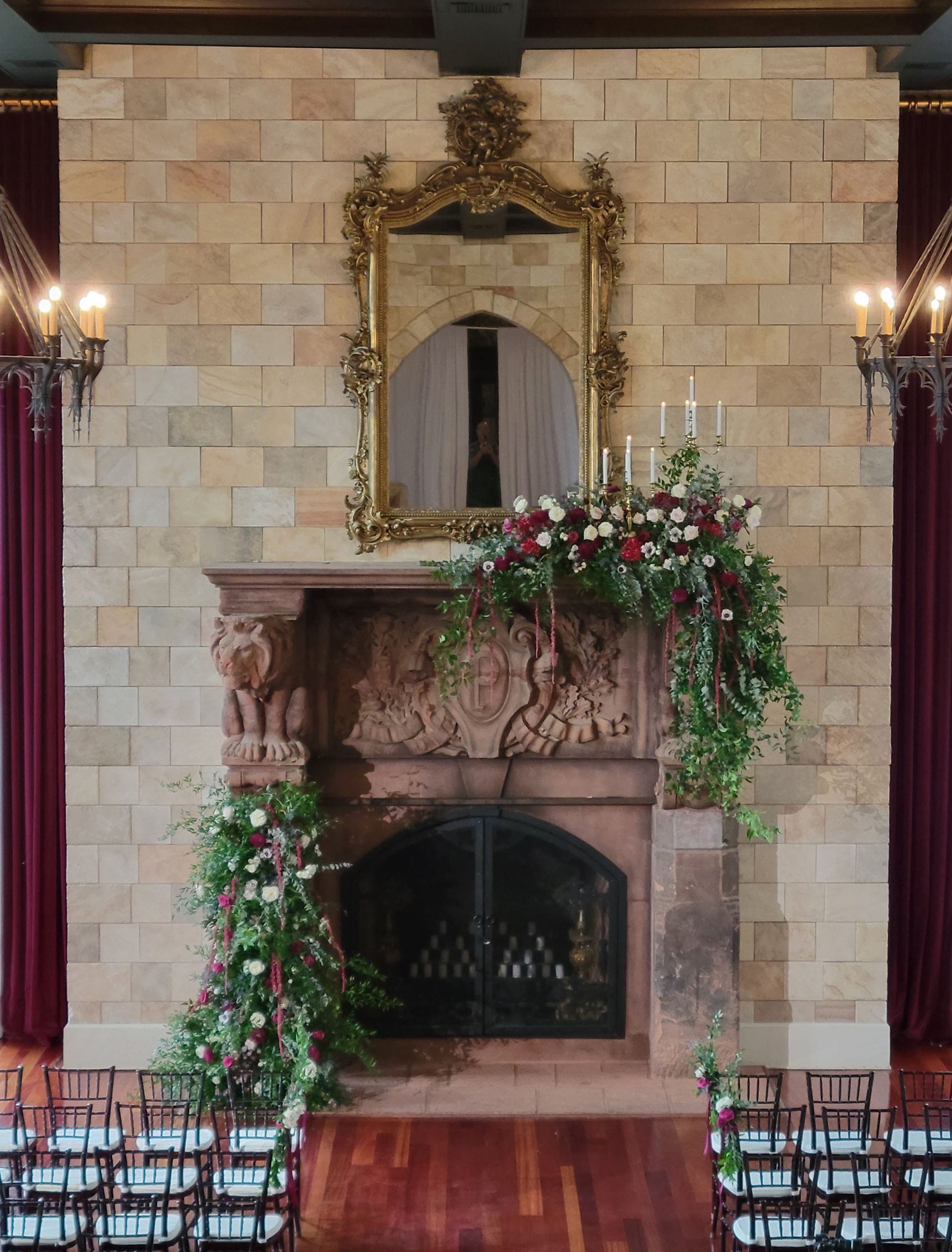 A fireplace with flowers on it and a mirror above it